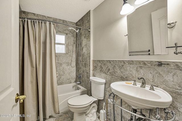 full bathroom with toilet, sink, tile walls, a textured ceiling, and shower / bath combo with shower curtain