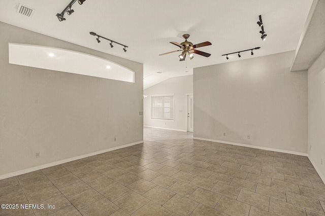 tiled empty room featuring ceiling fan, track lighting, and vaulted ceiling