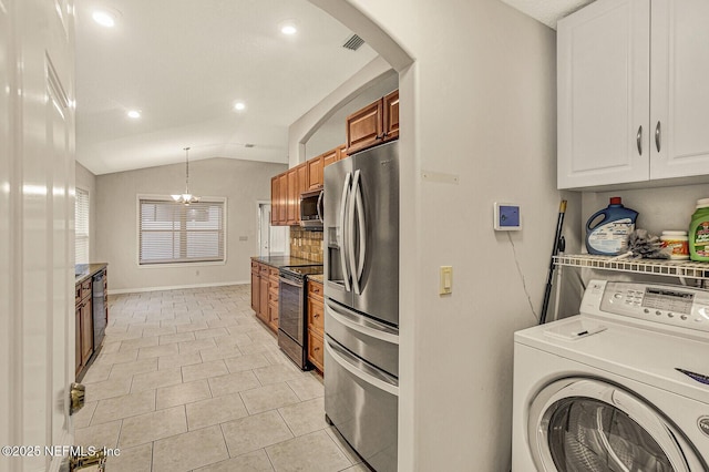 kitchen with pendant lighting, appliances with stainless steel finishes, white cabinets, washer / clothes dryer, and vaulted ceiling