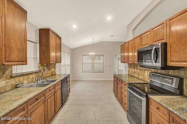 kitchen featuring lofted ceiling, sink, hanging light fixtures, light stone counters, and stainless steel appliances