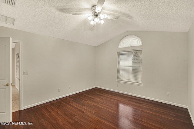 empty room featuring vaulted ceiling, dark wood-type flooring, a textured ceiling, and ceiling fan