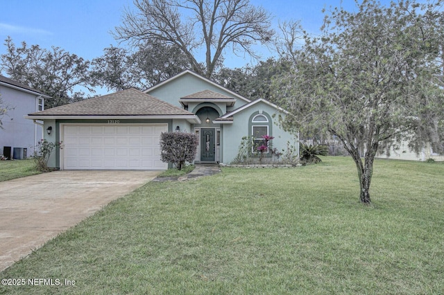 view of front of house with cooling unit, a garage, and a front yard