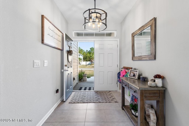 tiled foyer entrance with a chandelier