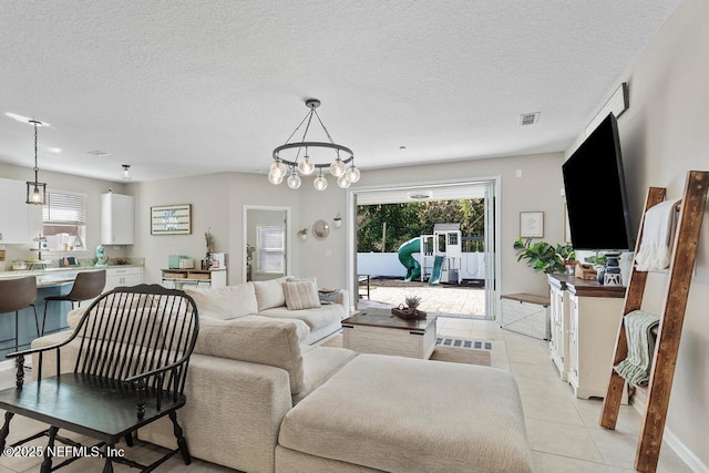 living room with a wealth of natural light, light tile patterned floors, and a textured ceiling