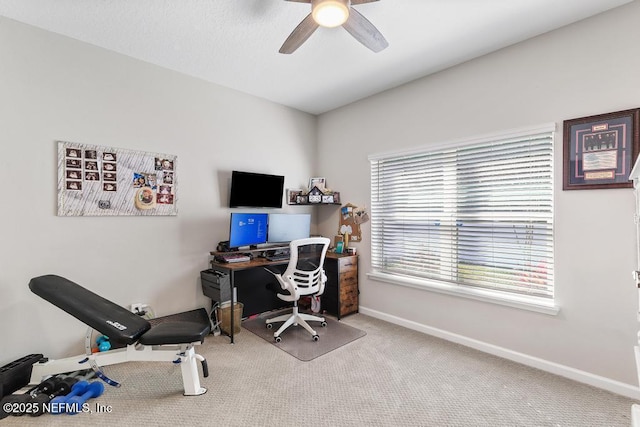 carpeted office space featuring ceiling fan