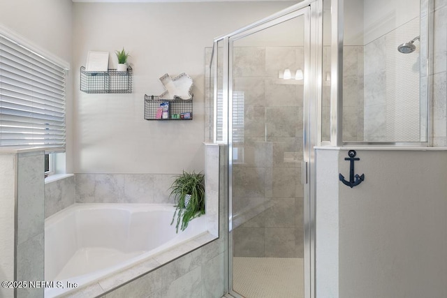 bathroom featuring plenty of natural light and shower with separate bathtub