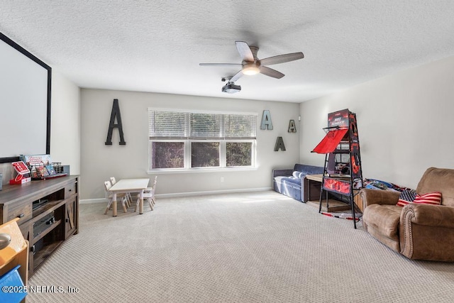 game room with ceiling fan, a textured ceiling, and light carpet