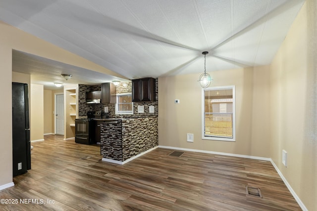 kitchen featuring dark brown cabinets, dark wood-type flooring, backsplash, and electric stove