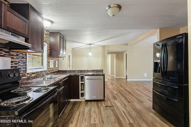 kitchen with black appliances, light hardwood / wood-style floors, tasteful backsplash, sink, and decorative light fixtures