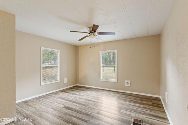 spare room featuring ceiling fan, a healthy amount of sunlight, light hardwood / wood-style flooring, and a textured ceiling