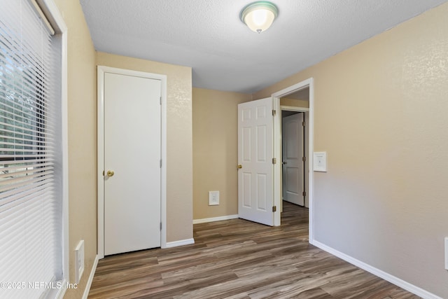 unfurnished bedroom featuring a textured ceiling and wood-type flooring