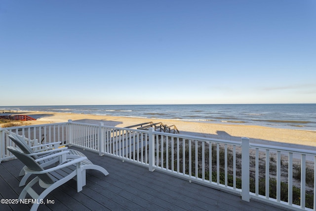 wooden deck featuring a view of the beach and a water view