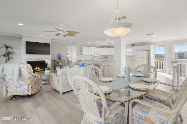 dining area with ornamental molding, ceiling fan, and light hardwood / wood-style flooring