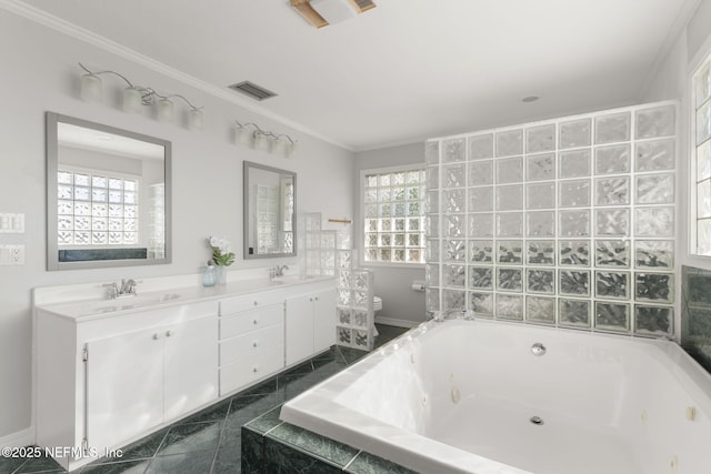 bathroom featuring a healthy amount of sunlight, toilet, tiled bath, and vanity