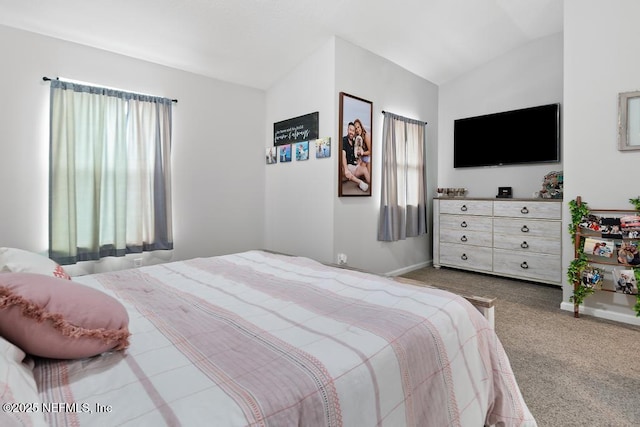 bedroom with vaulted ceiling, carpet floors, and multiple windows