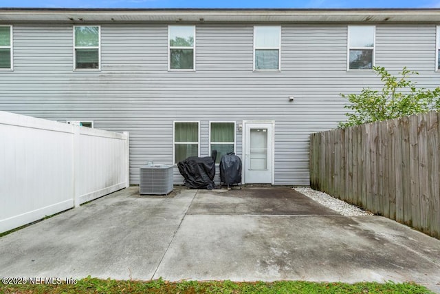 rear view of property featuring cooling unit and a patio area