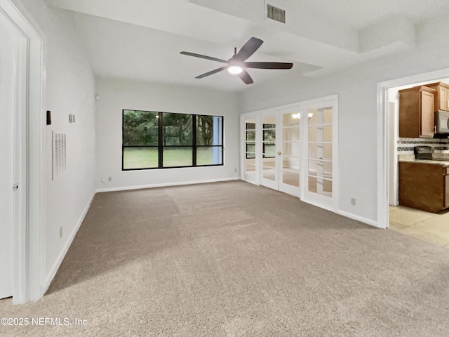 unfurnished living room featuring ceiling fan, french doors, and light colored carpet