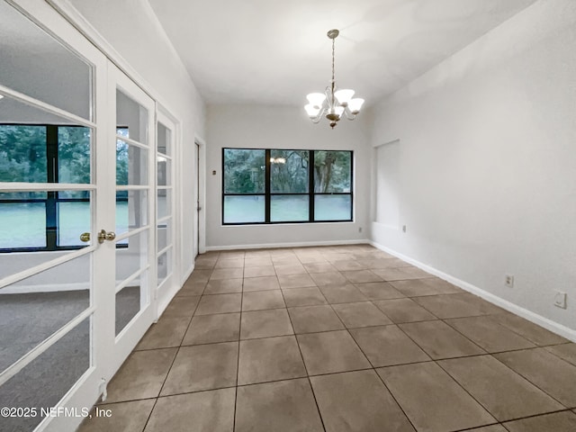 unfurnished dining area featuring a chandelier and tile patterned flooring