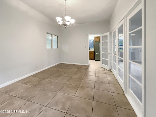 tiled empty room with a chandelier