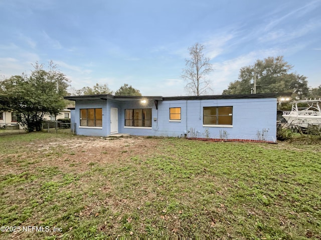 rear view of property featuring a yard