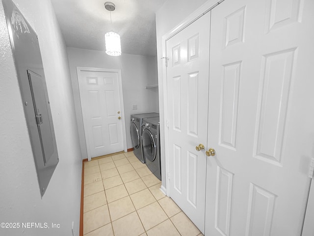 washroom with washer and clothes dryer, light tile patterned floors, and a textured ceiling