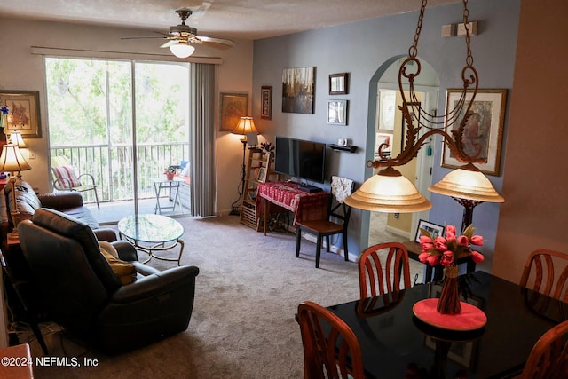 living room with a textured ceiling, light colored carpet, and ceiling fan