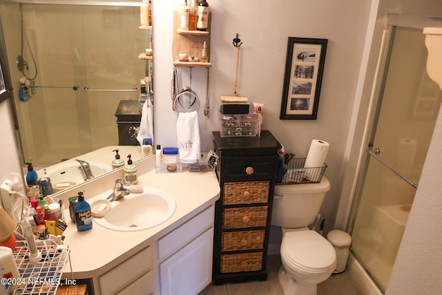 bathroom featuring a shower with door, toilet, and vanity