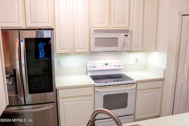 kitchen with white appliances and white cabinets