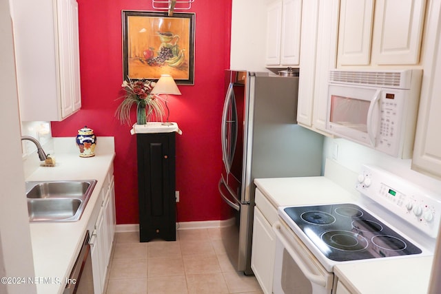 kitchen with light tile patterned floors, sink, white appliances, and white cabinets