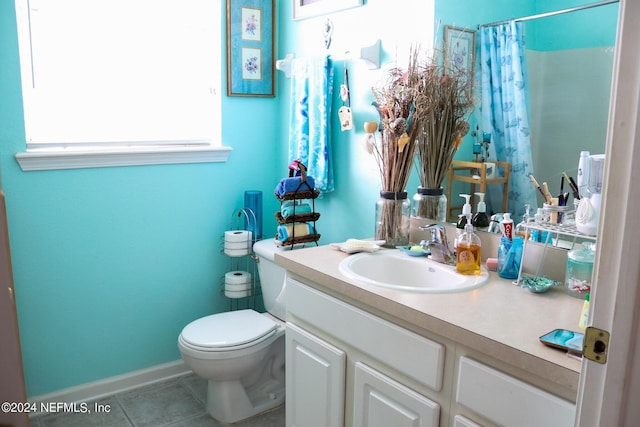 bathroom with a shower with curtain, toilet, tile patterned flooring, and vanity