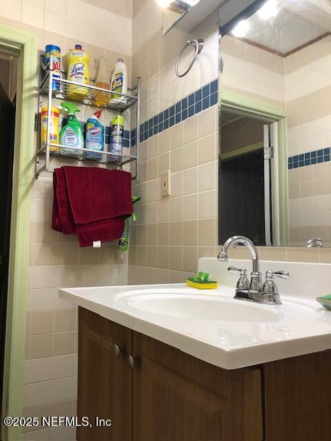 bathroom featuring tile walls and vanity