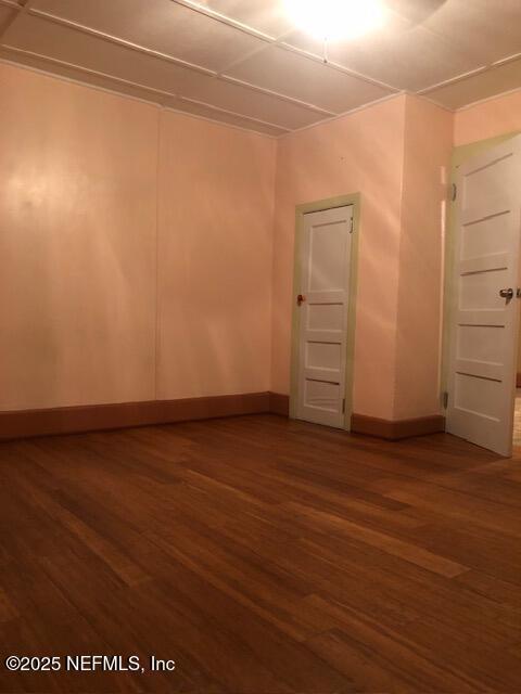 unfurnished room with dark hardwood / wood-style floors