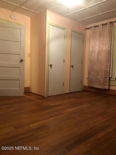 unfurnished bedroom with dark hardwood / wood-style flooring