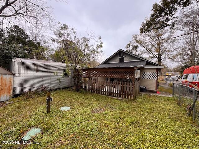 rear view of property featuring a lawn