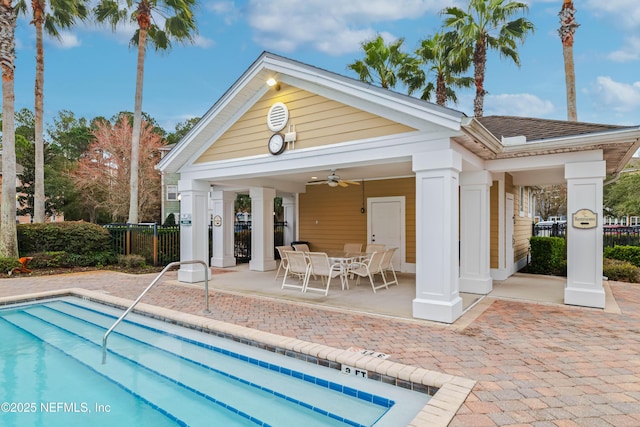 view of swimming pool featuring ceiling fan, an outdoor structure, and a patio area