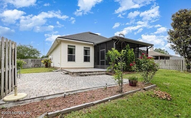 back of house with a sunroom, a yard, and a patio