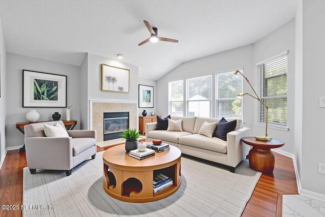 1560 Timber Trace Dr, Saint Augustine, FL 32092 - living room featuring plenty of natural light, ceiling fan, a fireplace, vaulted ceiling, and a textured ceiling