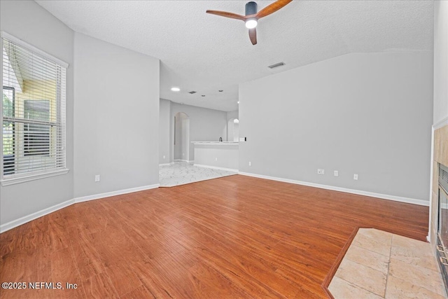 1560 Timber Trace Dr, Saint Augustine, FL 32092 - unfurnished living room with wood finished floors, arched walkways, a ceiling fan, and a textured ceiling