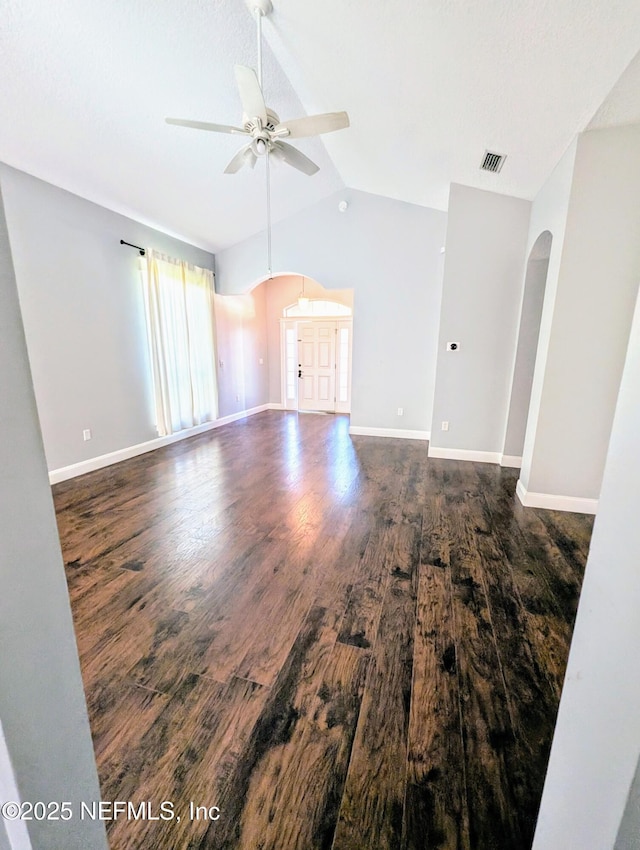 unfurnished living room with lofted ceiling, dark wood-type flooring, and ceiling fan