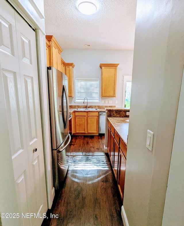 kitchen with dark hardwood / wood-style flooring, sink, a textured ceiling, and appliances with stainless steel finishes