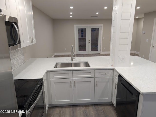 kitchen featuring black dishwasher, sink, white cabinets, and electric stove