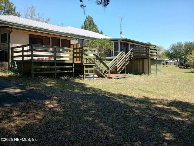 back of property with a wooden deck and a lawn