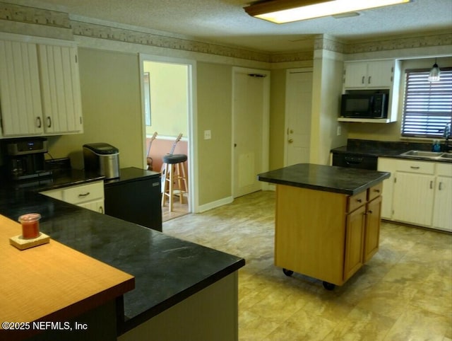 kitchen with sink, a textured ceiling, and a kitchen island