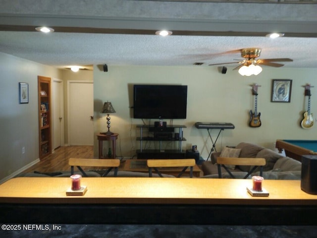 living room with wood-type flooring, a textured ceiling, and ceiling fan