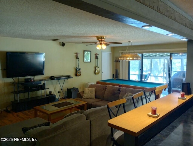 living room with hardwood / wood-style flooring, ceiling fan, a textured ceiling, and pool table