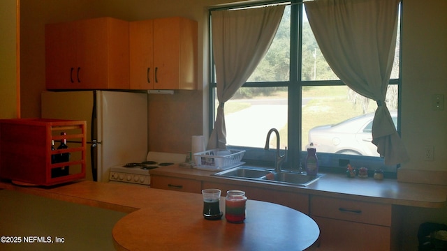 kitchen featuring sink, white appliances, and washer / dryer