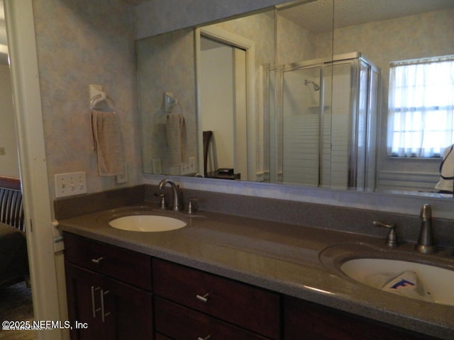 bathroom featuring a shower with door and vanity