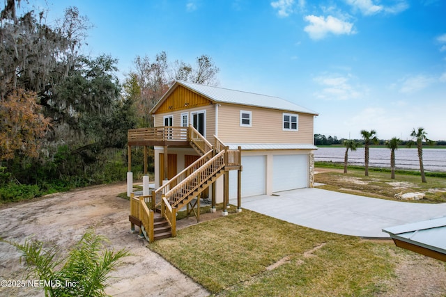 view of front of house with a water view, a garage, and a front lawn