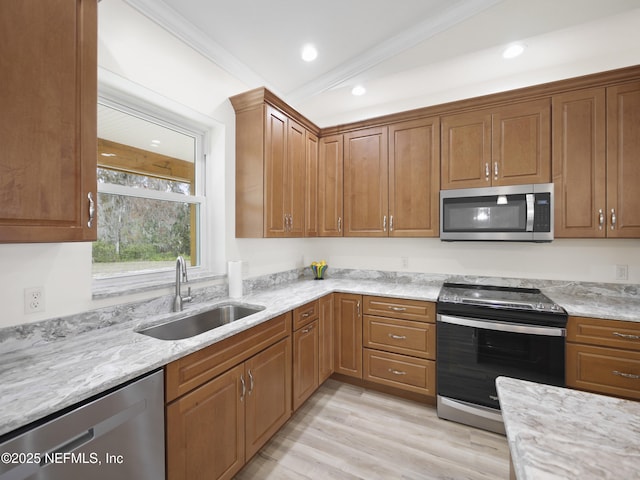 kitchen featuring light stone counters, sink, light hardwood / wood-style flooring, and stainless steel appliances