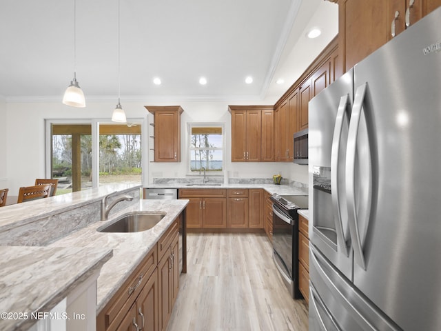 kitchen with light stone counters, sink, decorative light fixtures, and stainless steel appliances